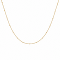 Fine 9k yellow gold curb chain necklace with small polished bead details on a white background